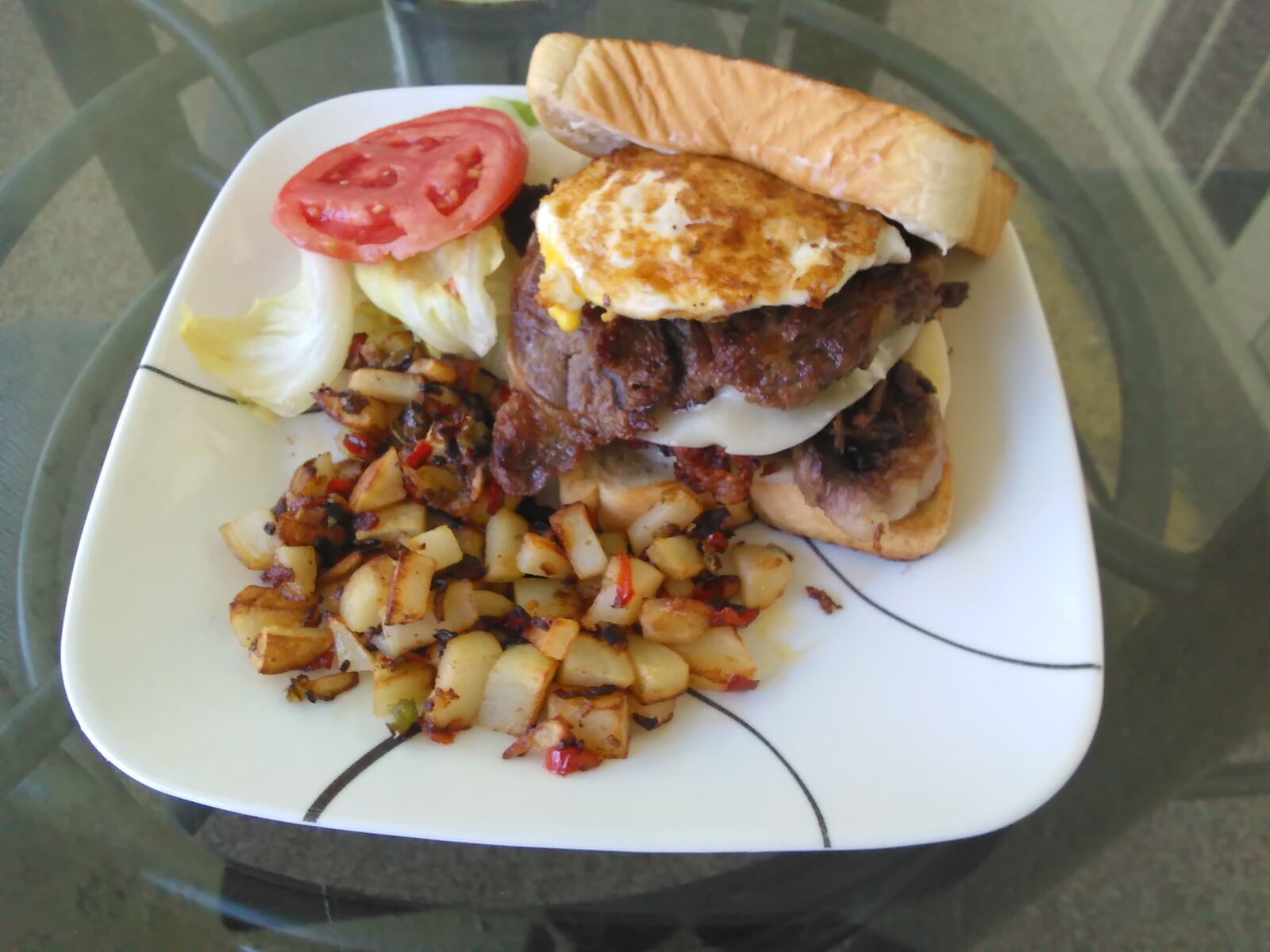 Burger topped with a fried egg and crispy potatoes